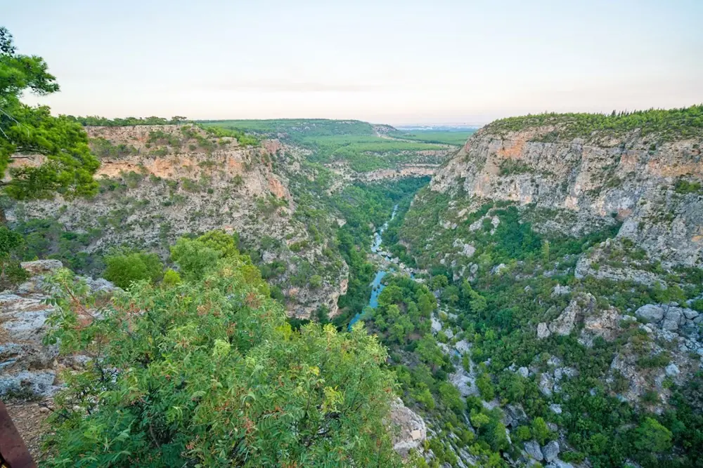 Güver Uçurumu - Döşemealtı sınırlarındaki Güver Uçurumu, karstik kayaların milyonlarca yıl süren aşınmasıyla oluşmuş etkileyici kanyonudur; panoramik manzaralar ve zengin bitki örtüsü sunar. - Döşemealtı turistik yerler ve tarihi mekanlar